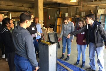 Our CAWST volunteer shows students the best way to prep the metal mold for concrete pouring.