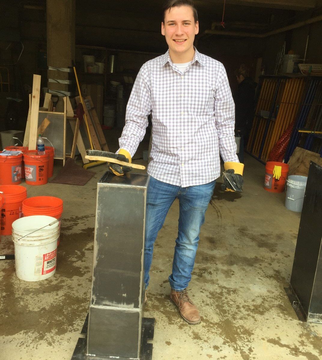 A student poses next to one of our two metal water filter molds.